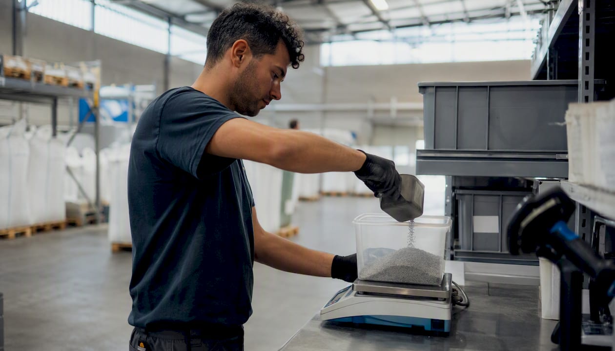 Operatore che distribuisce materie prime nel magazzino industriale