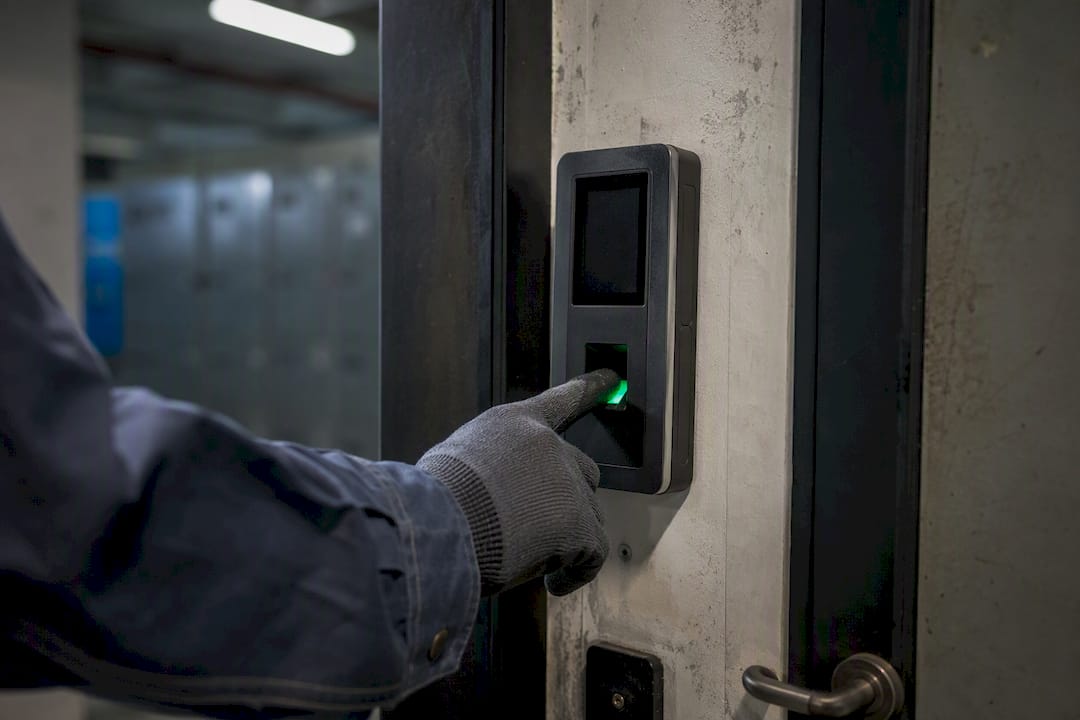 Tecnico che usa un lettore di impronte digitali alla porta della fabbrica
