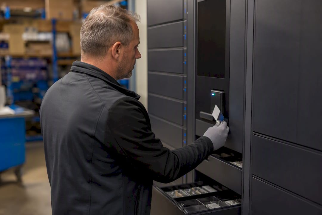 Tecnico che utilizza un badge per ritirare materiale da un armadio intelligente